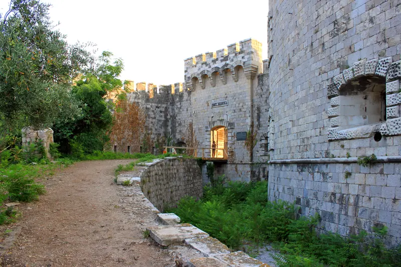 The thick stone ramparts and gate of Fort Mamula, the round Austro-Hungarian island fortress at the mouth of the Bay of Kotor