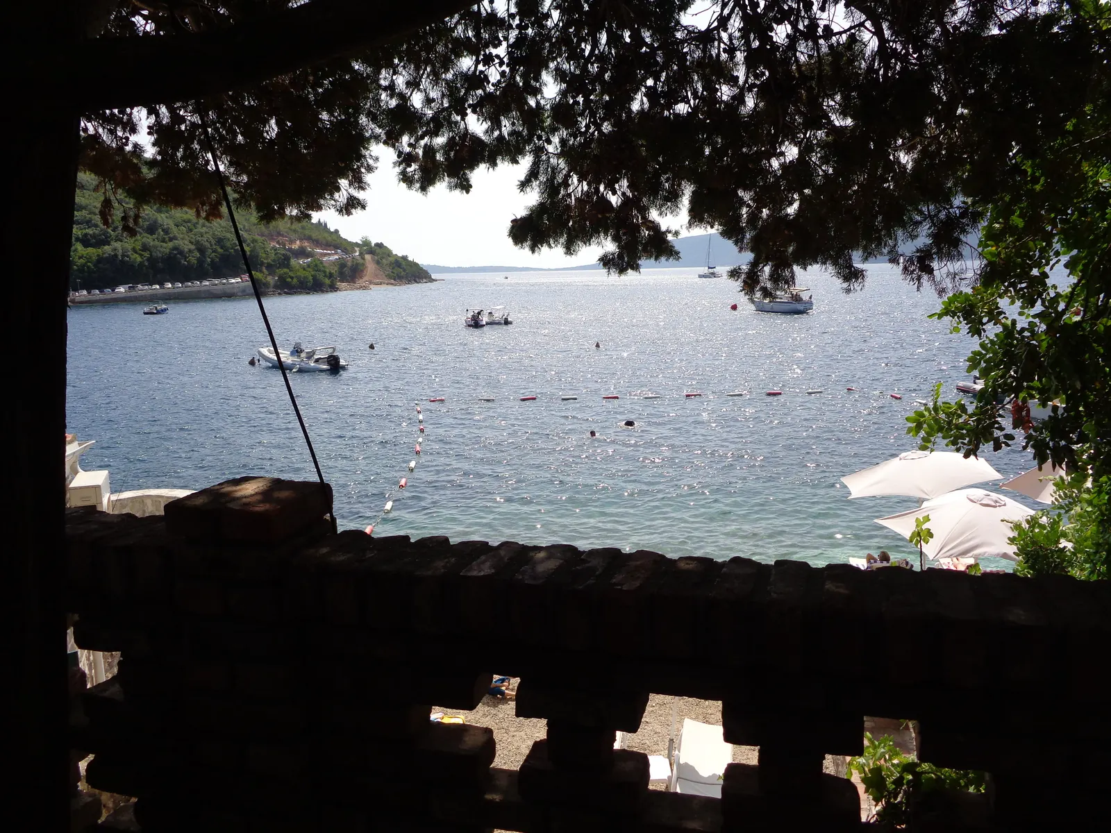 The quiet waterfront of Rose village on the Luštica shore, fishing boats moored on the calm Boka Kotorska