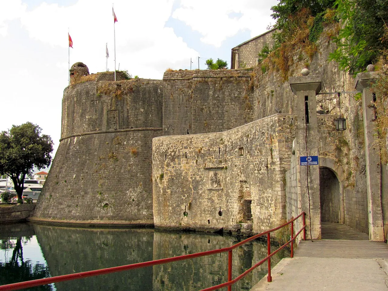 The level paved quayside and ramp running alongside Kotor's Old Town walls up to the South Gate, the moat alongside