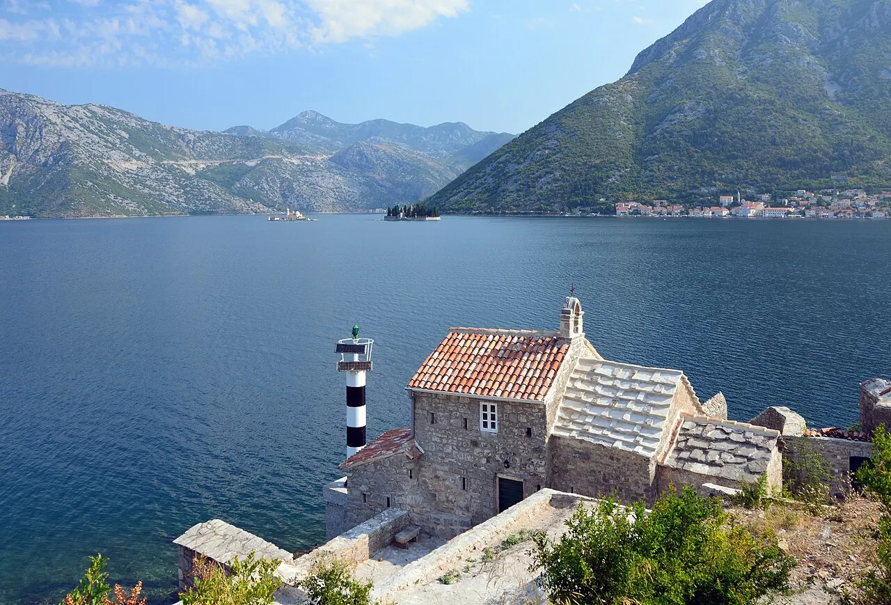 The inner Bay of Kotor from the Lepetani road, with Perast and its two island churches in the distance and a shoreline chapel