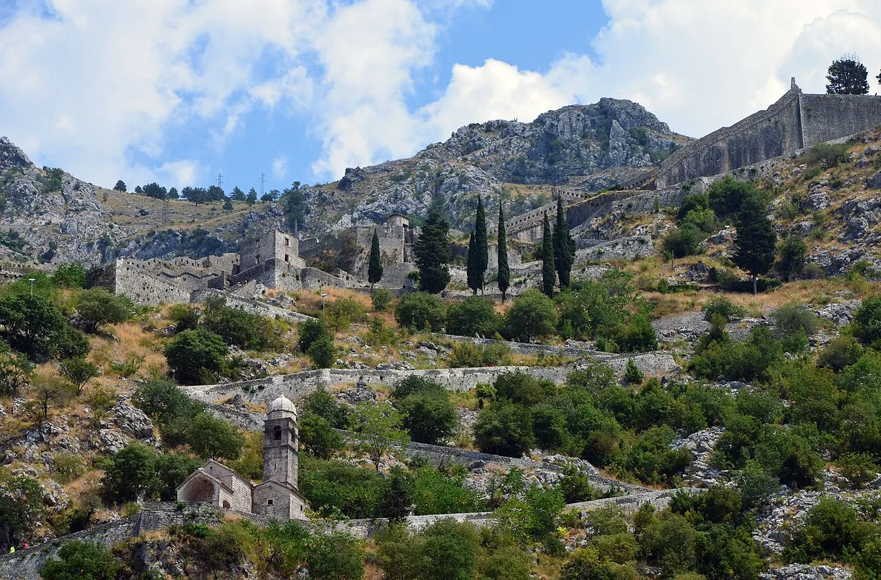 Kotor's fortification walls zig-zagging up the rocky mountainside toward St John's castle above the Old Town