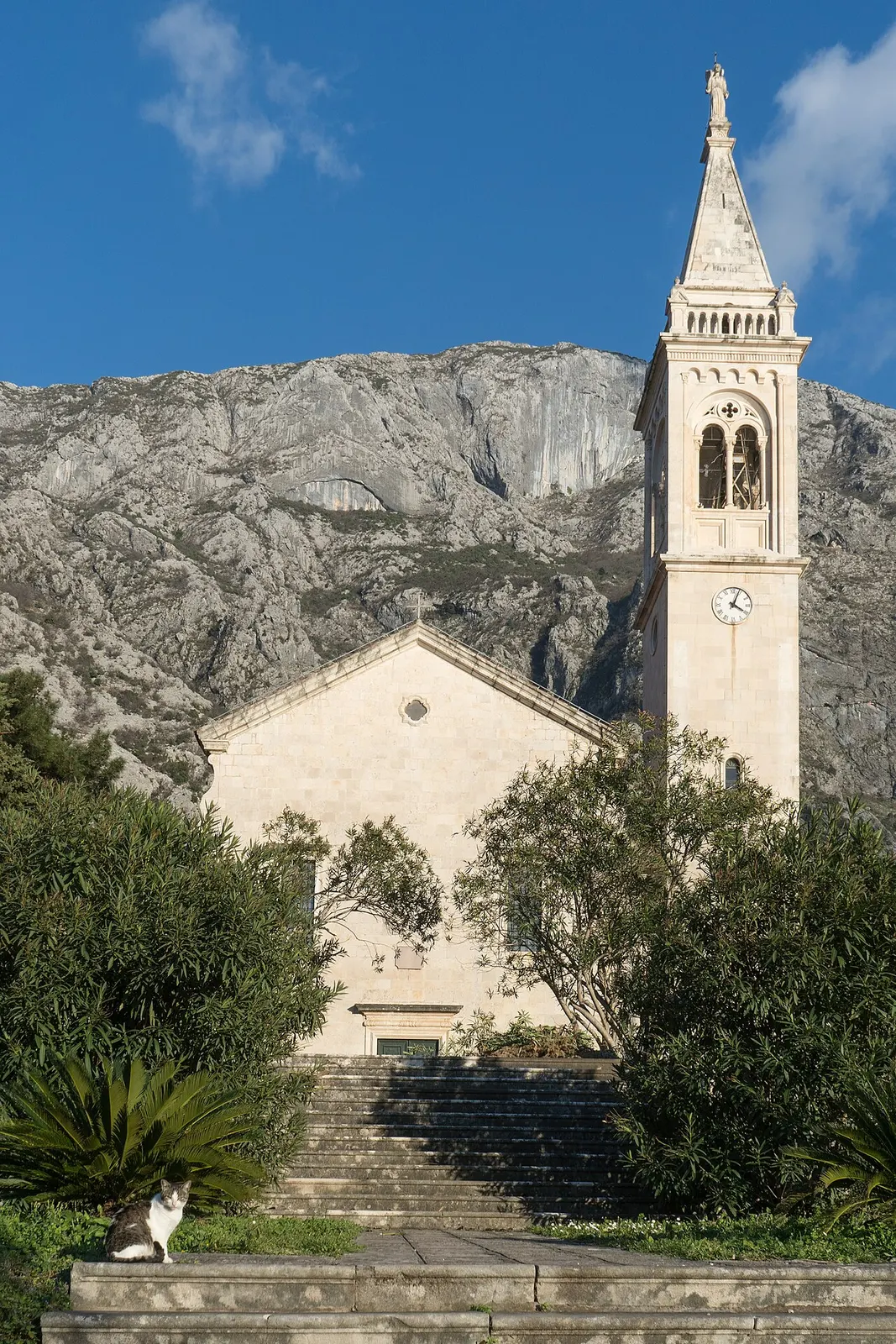 The baroque Church of St Eustace (Sveti Stasije) on the Dobrota waterfront, its bell tower against the mountain