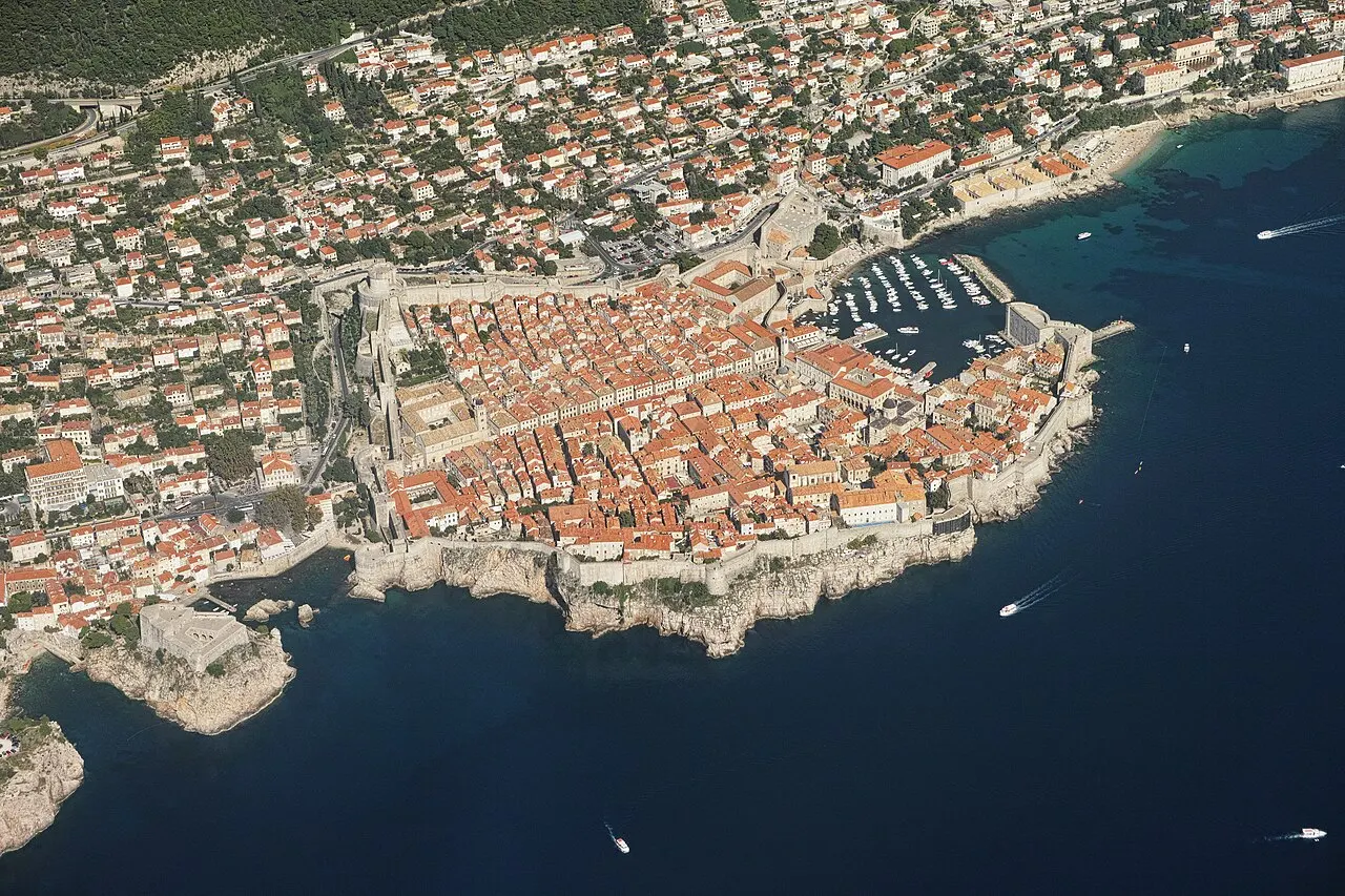 Aerial view of Dubrovnik Old Town, its city walls and terracotta rooftops jutting into the Adriatic