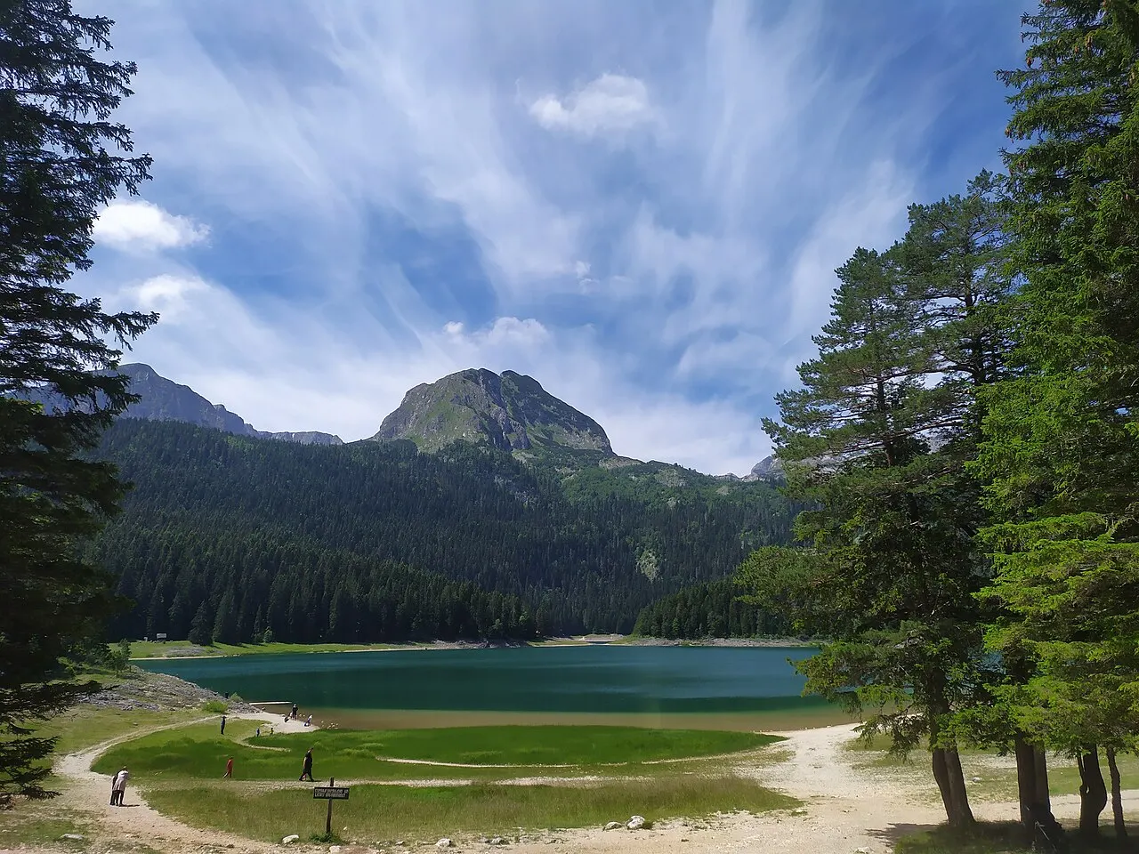 The Black Lake (Crno jezero) ringed by pine forest with Durmitor peaks reflected in its still surface