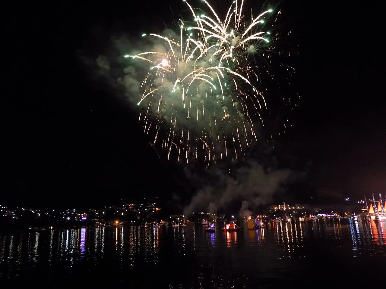 Fireworks bursting over the Bay of Kotor above lit boats during the summer Boka Night Festival