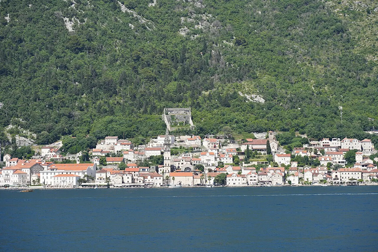 Perast and its bell tower on the Bay of Kotor, the islands on glassy water