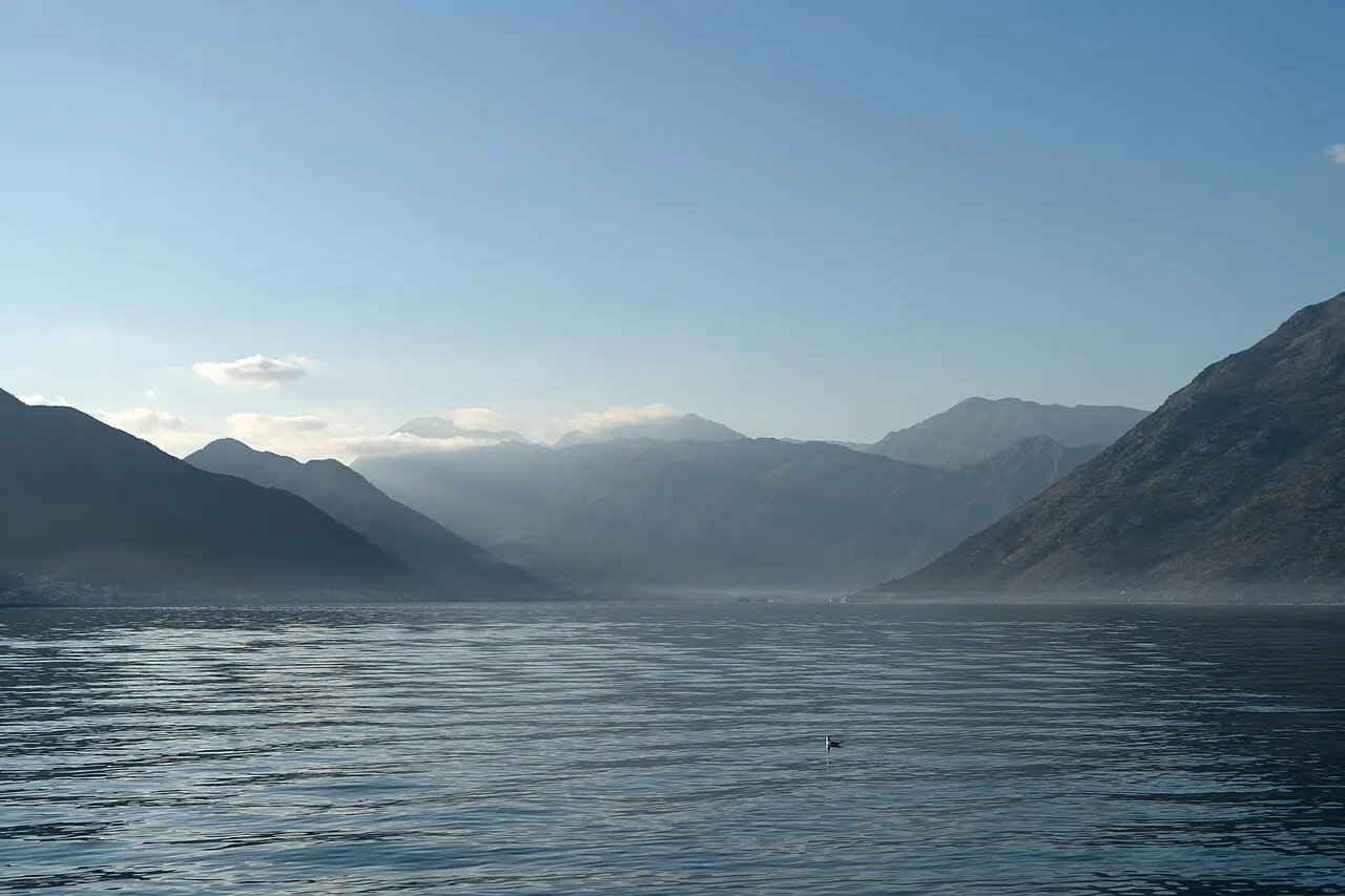 The mountain-walled inner Bay of Kotor with calm clear water at Sveti Stasije, Dobrota