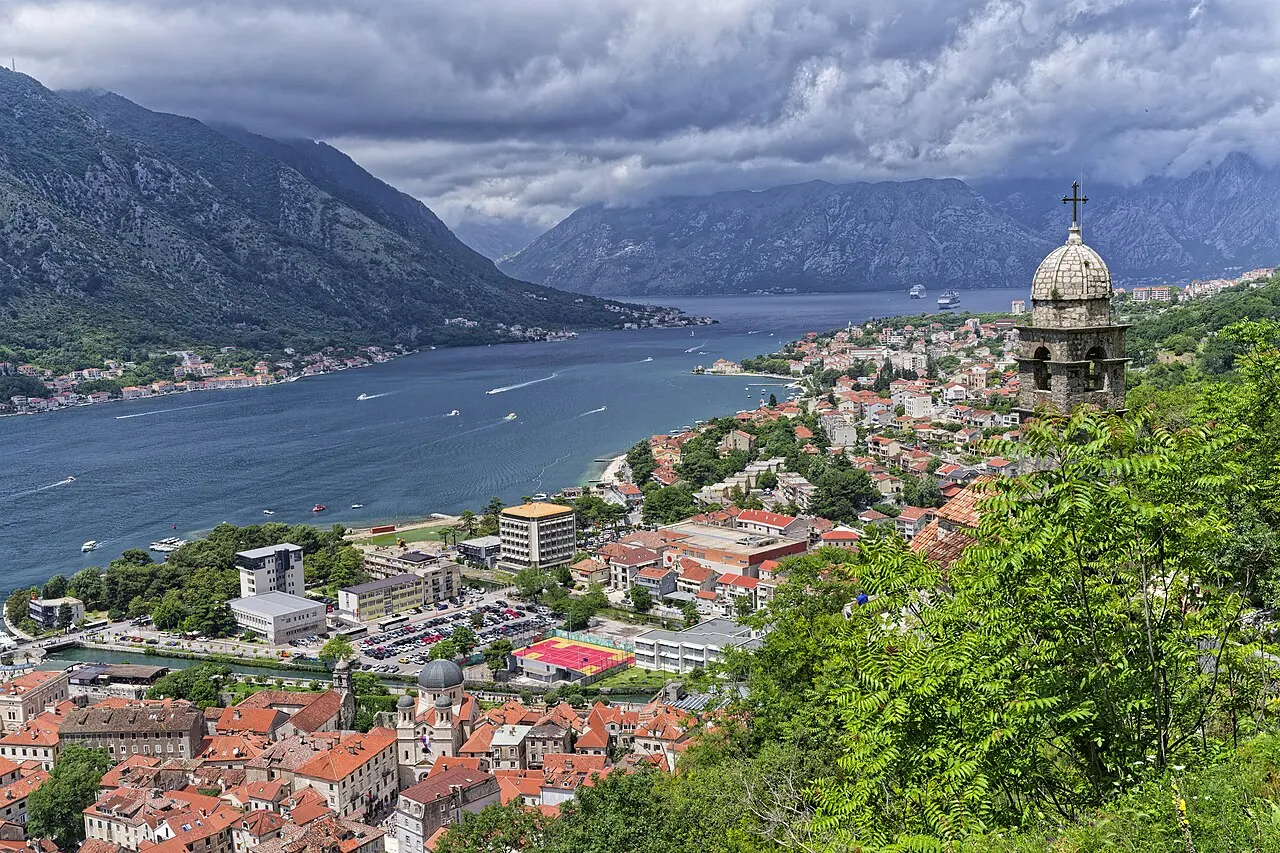 Panorama over Kotor's Old Town roofs and the Bay of Kotor seen from the wall climb, mountains all around