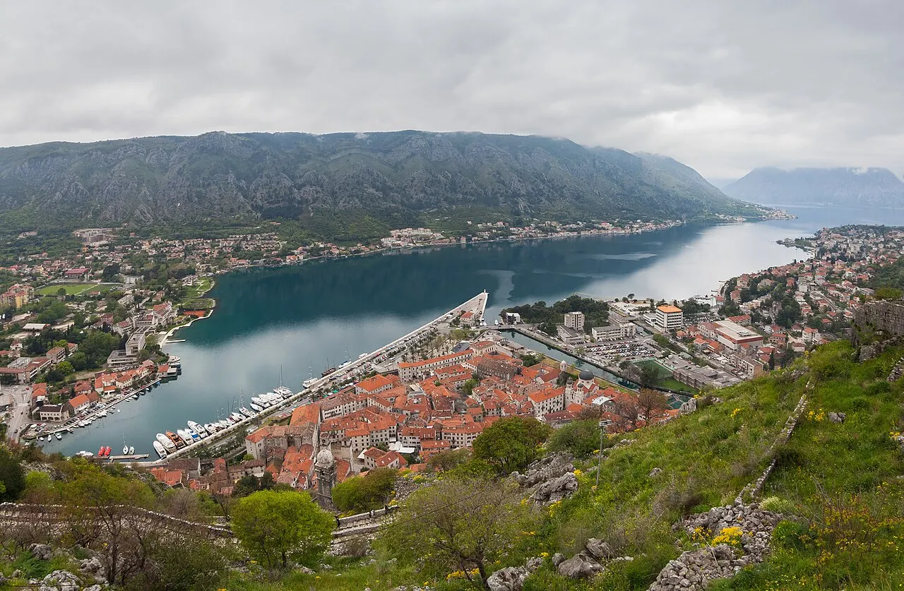 High panorama of the full Bay of Kotor, the Old Town and marina far below the surrounding mountains