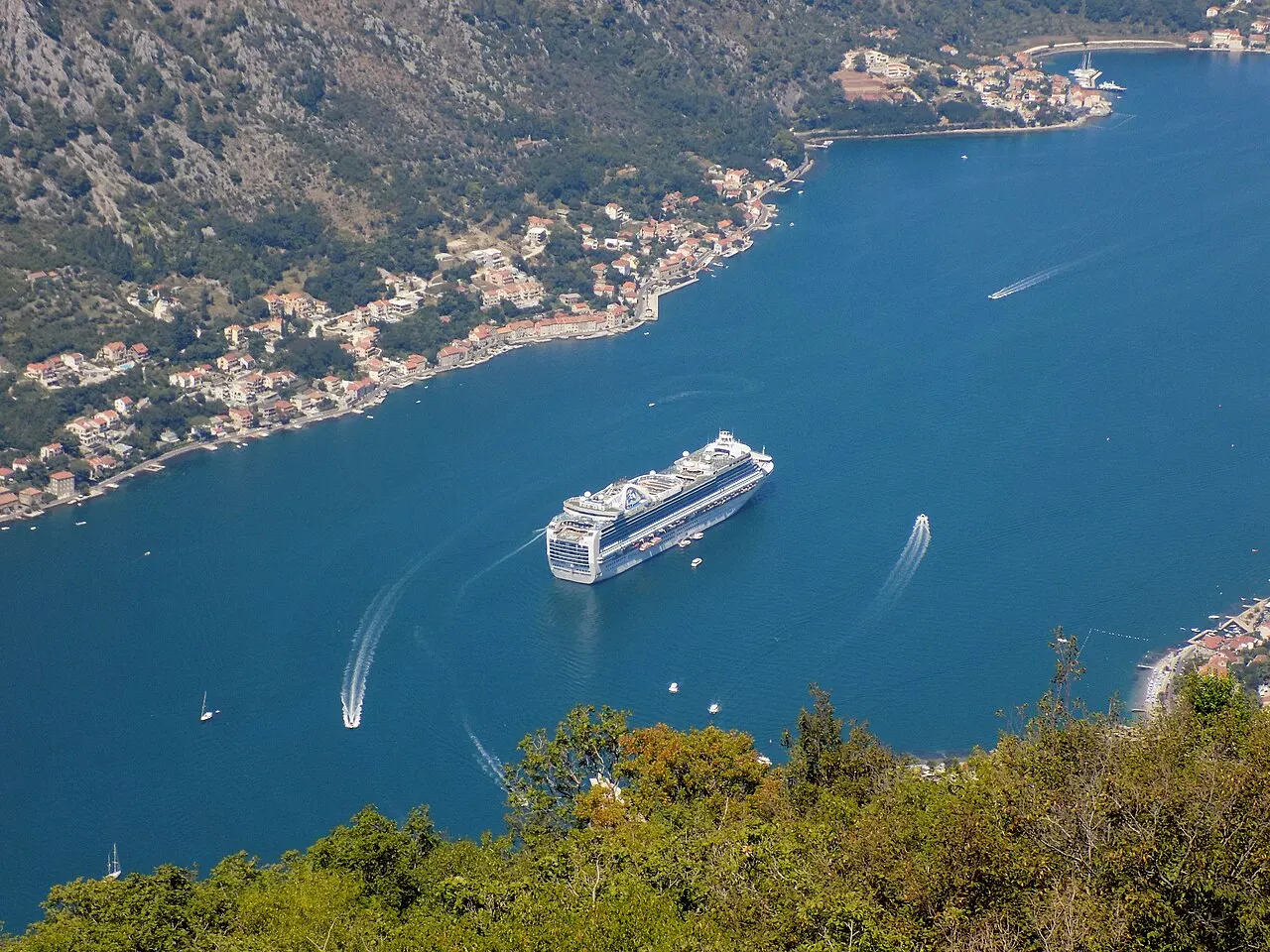 A cruise ship moored on the Bay of Kotor beside the Old Town below the mountains