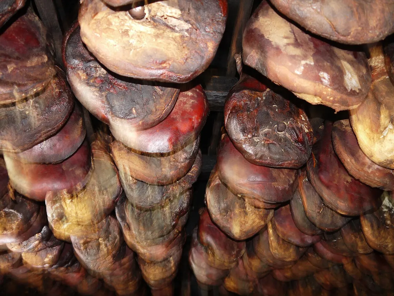 Hams curing on racks in a traditional Njeguši smokehouse above the Bay of Kotor