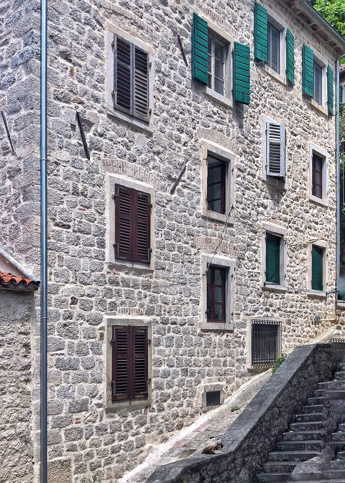 A shuttered stone building frontage on a quiet lane in Kotor Old Town