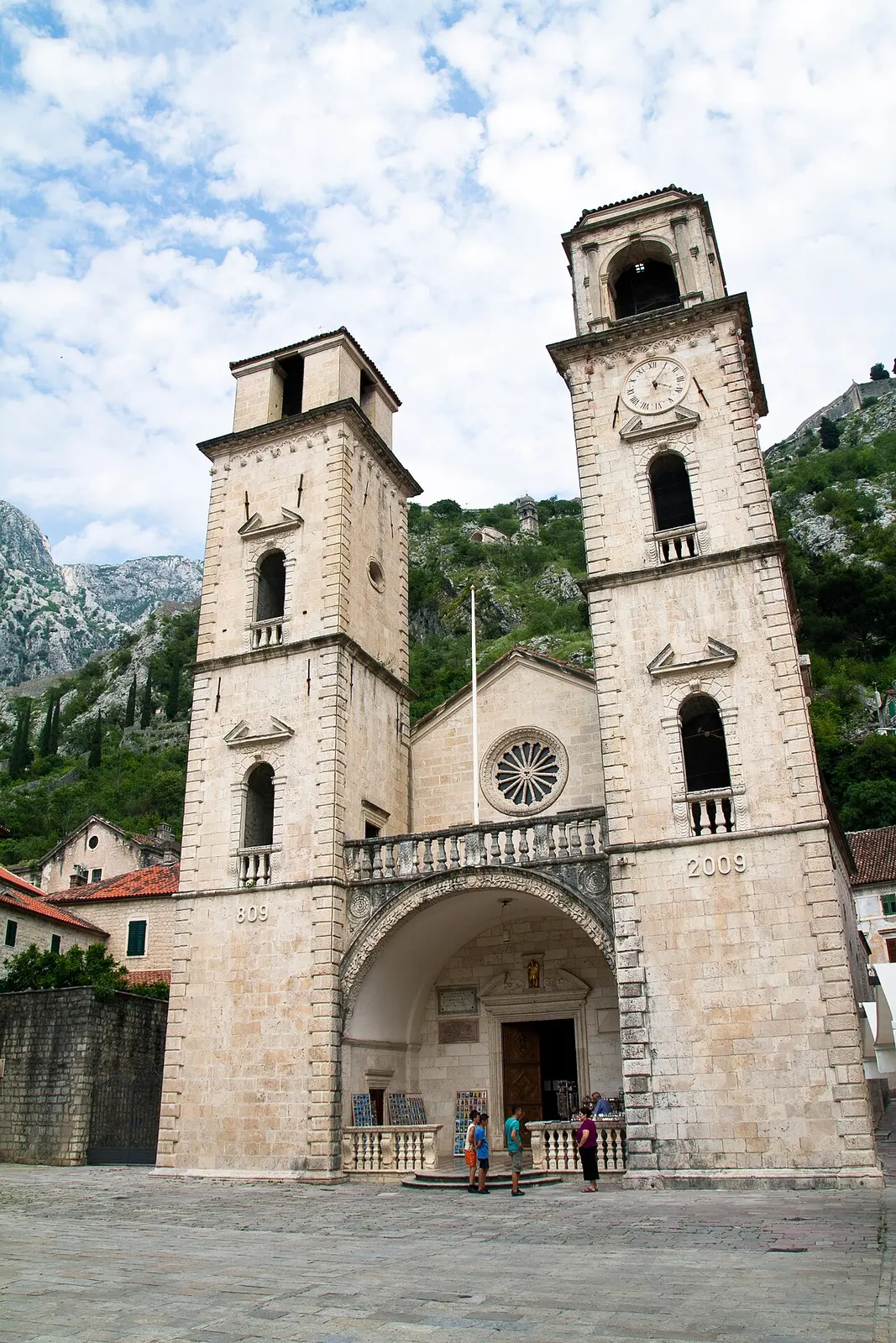 The twin-towered facade of St Tryphon Cathedral in Kotor under an overcast sky