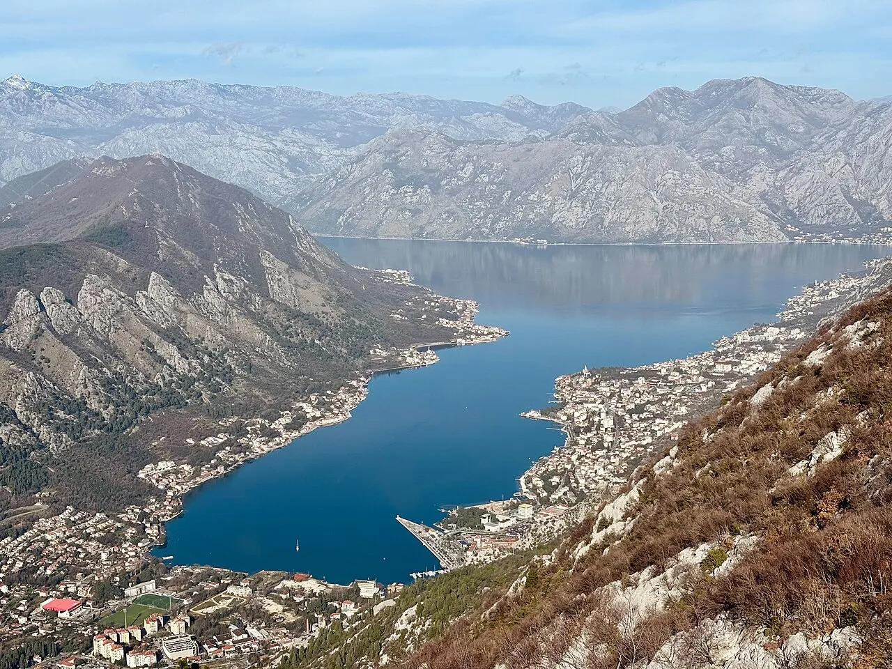 Aerial view of the Bay of Kotor amphitheatre with the walled town beneath steep limestone cliffs