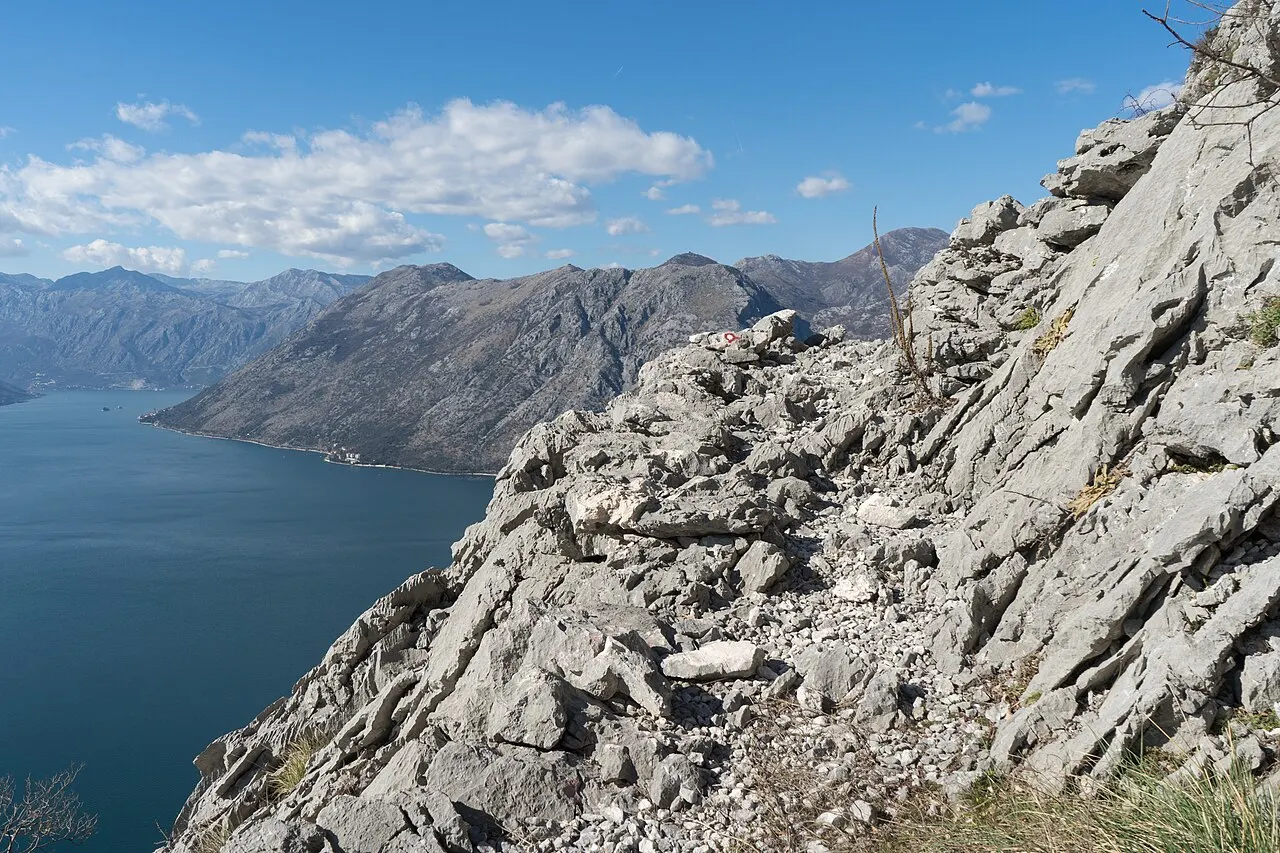 A rocky footpath traversing the open mountainside high above the Bay of Kotor