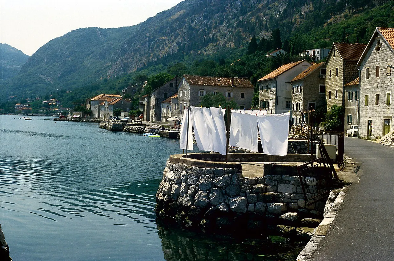 The waterfront at Muo on the western shore of the Bay of Kotor, stone houses and the bay road alongside the water