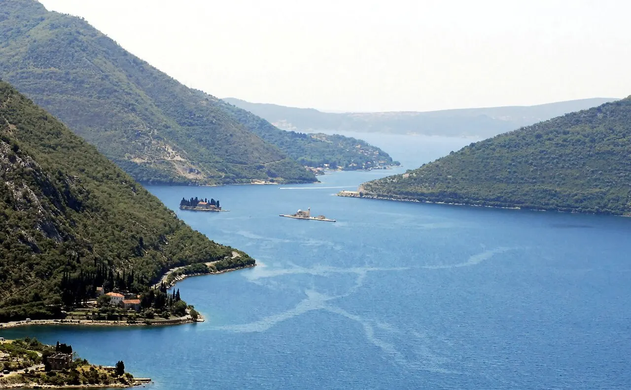 The narrow Verige strait of the Bay of Kotor, islets in the channel and mountains rising on both sides
