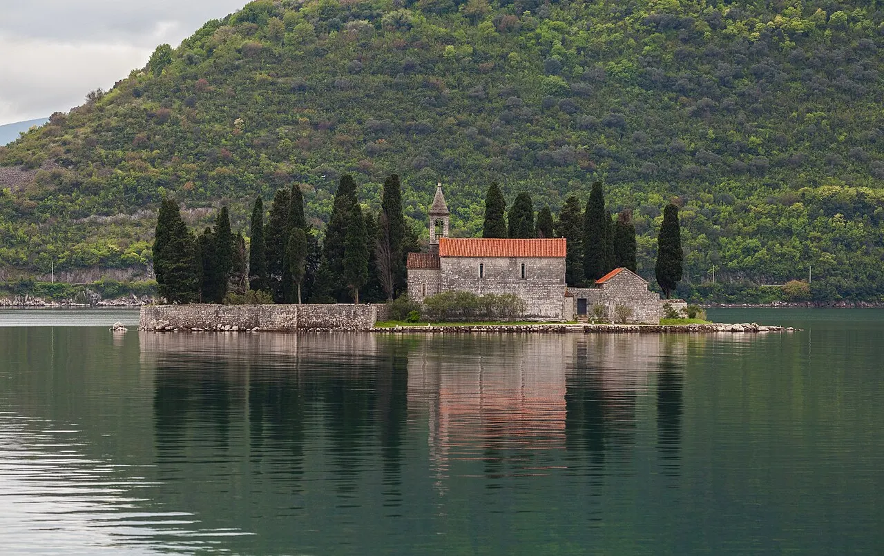 Close view of St George island near Perast, the Benedictine monastery half-hidden among tall cypress trees