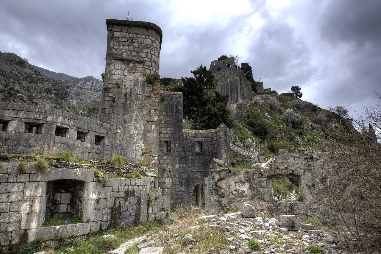 Weathered stone bastions and ruined walls standing at the top of St John Fortress above Kotor