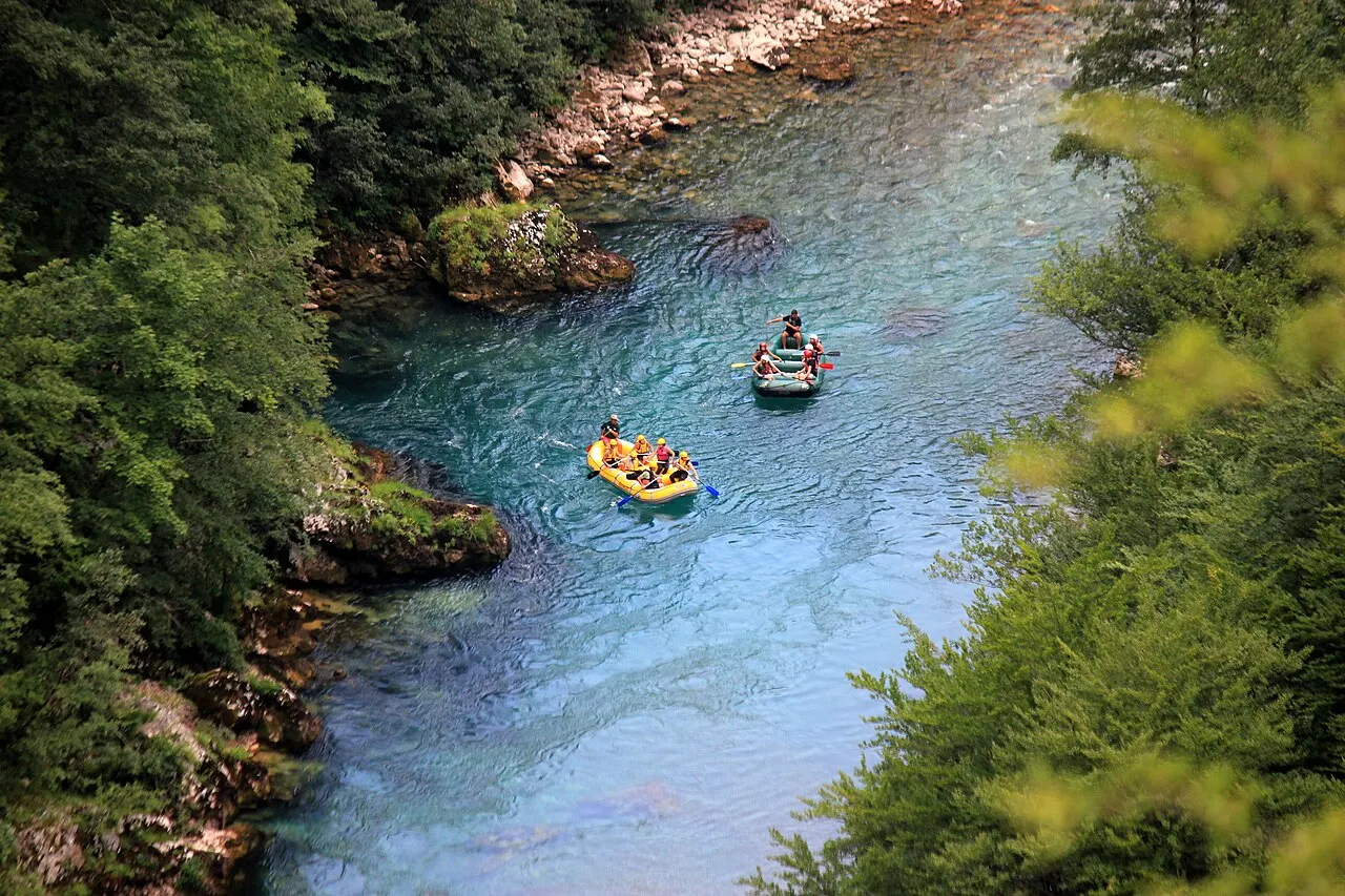 Paddlers in a raft pushing through white water on the Tara River in Montenegro