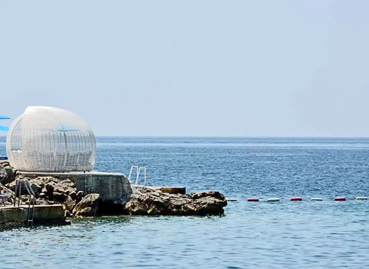 The white-pebble curve of Zanjice beach and clear water in the Bay of Kotor